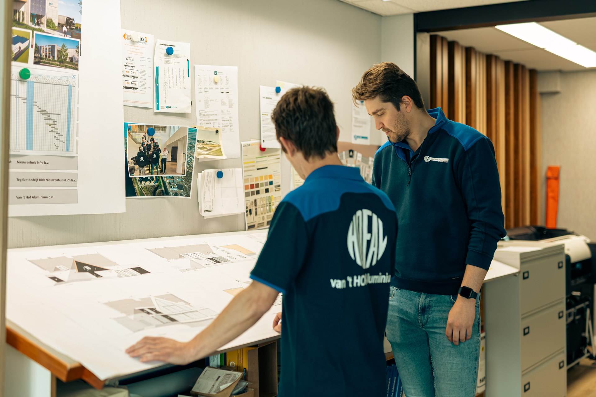 Medewerkers van Van ’t Hof bespreken een bouwtekening